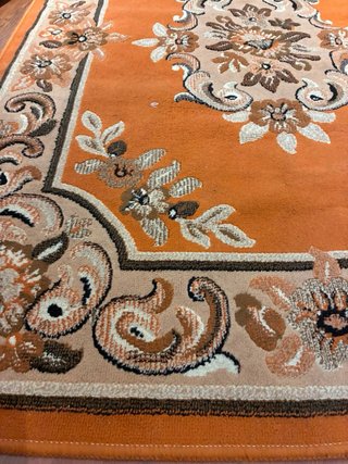 Alfombra naranja y marrón con diseño floral