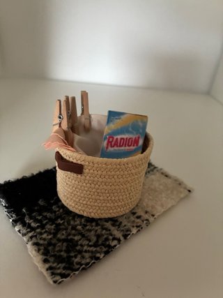 Cestino in miniatura con vestiti e mollette