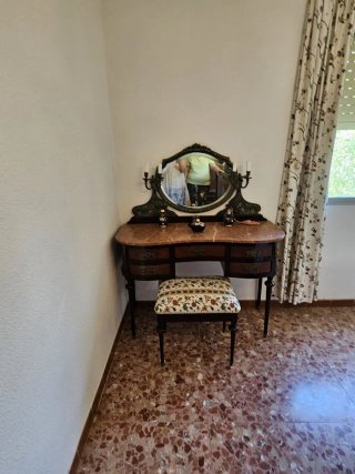 Dormitorio antiguo de madera y metal brocado.