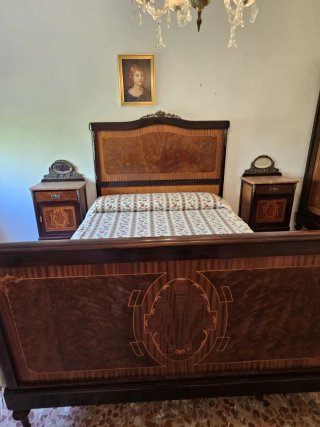 Dormitorio antiguo de madera y metal brocado.