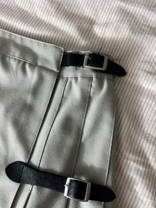 Falda plisada gris con hebillas