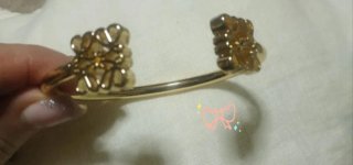 Pulsera dorada con diseño floral