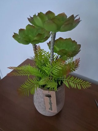 Maceta terracota con plantas artificiales.