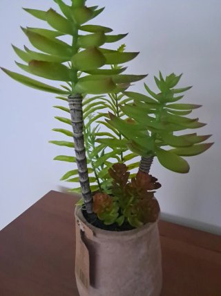 Maceta terracota con plantas artificiales.