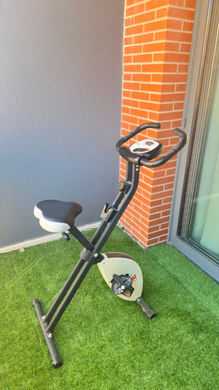 Banco de pesas con pesas y bicicleta estática
