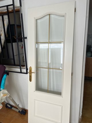 Puerta interior con cristal y marco dorado