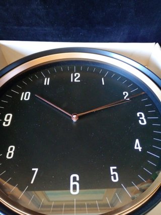 Reloj de pared negro y dorado