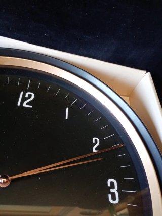 Reloj de pared negro y dorado