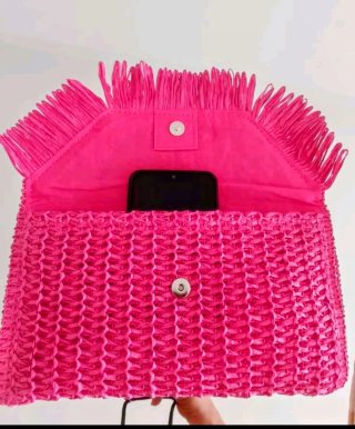 Cartera de mano rosa con flecos