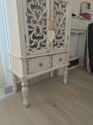 Aparador blanco de madera con puertas talladas.