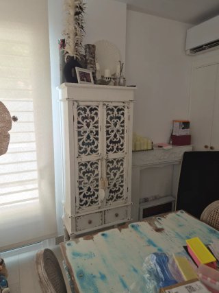Aparador blanco de madera con puertas talladas.