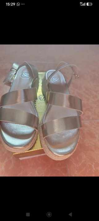 Sandalias doradas atadas al tobillo