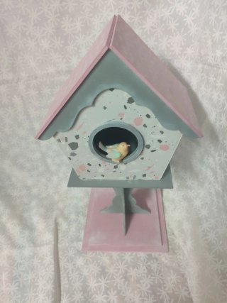 Casa de pájaros decorativa con peana