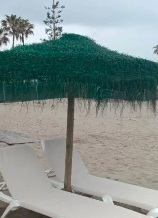 Se venden sombrillas de esparto completas con palo