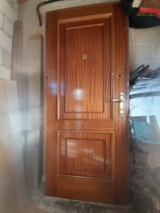 Puerta de entrada de madera, con 2 cerraduras.
