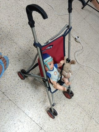 Muñeca con ojos azules y carrito