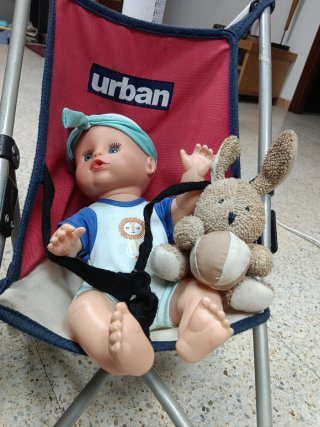 Muñeca con ojos azules y carrito