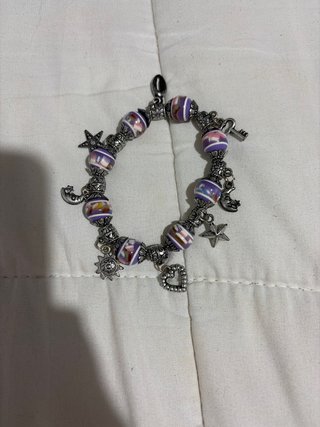 Pulsera morada con dijes de estrellas y luna