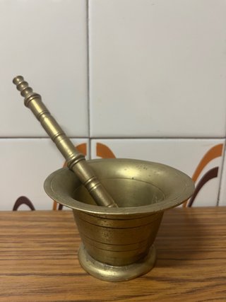 Mortero y mano de bronce