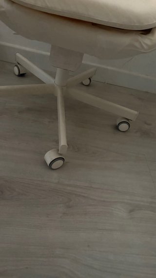 Silla de escritorio beige con ruedas.