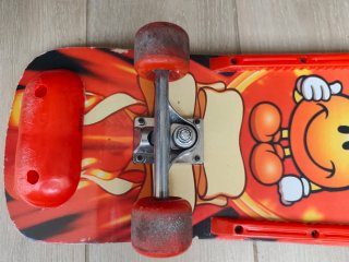 Monopatín con diseño de fuego y cara sonriente