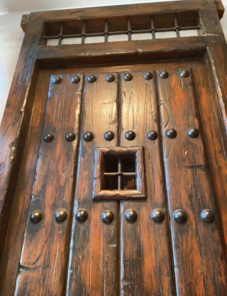 Puerta rústica madera con rejas y aldaba