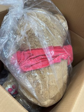 Oso de peluche marrón con bufanda roja
