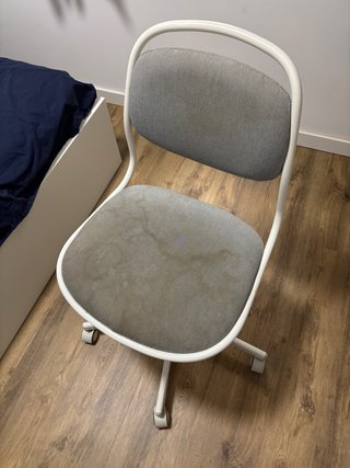Silla de oficina gris y blanca con manchas.