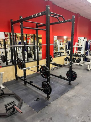 Rack de sentadillas con barra y discos
