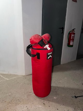 Saco de boxeo rojo con guantes