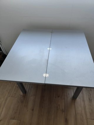 Mesa de cocina extensible de acero y cristal.