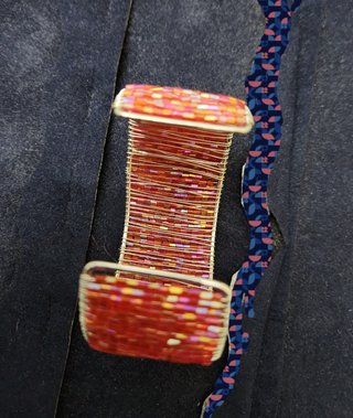 Braccialetto in perline rosa e filo dorato.