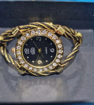 Reloj dorado y negro con pedrería