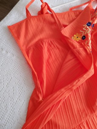 Vestido naranja con bordado floral.