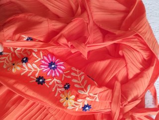 Vestido naranja con bordado floral.