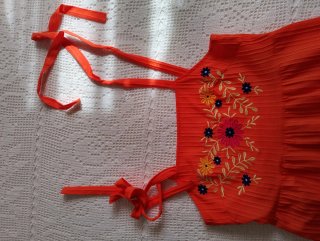 Vestido naranja con bordado floral.
