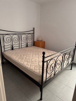 Cama de metal con colchón beige