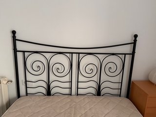 Cama de metal con colchón beige