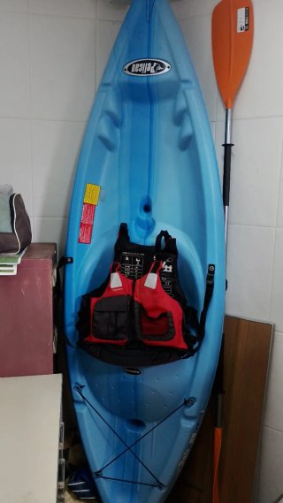 Kayak azul con chaleco y remo