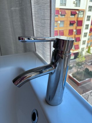 Mueble de baño verde con lavabo y grifo