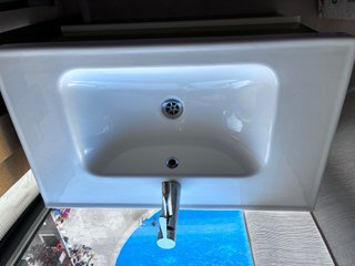 Mueble de baño verde con lavabo y grifo