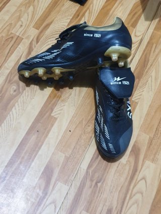 Zapatos de fútbol negros y dorados