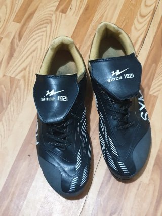 Zapatos de fútbol negros y dorados
