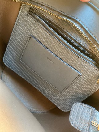 Bolso gris con textura de piel de serpiente