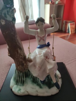 Figura de porcelana niña en columpio