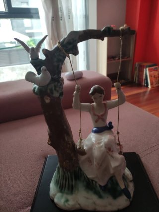 Figura de porcelana niña en columpio