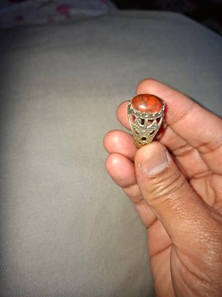 Anillo con piedra naranja y detalles plateados