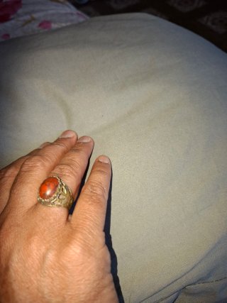 Anillo con piedra naranja y detalles plateados