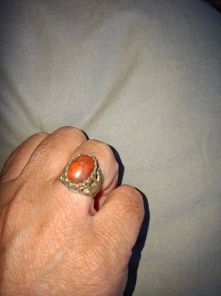 Anillo con piedra naranja y detalles plateados