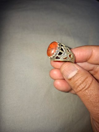 Anillo con piedra naranja y detalles plateados